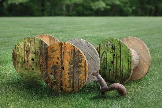 Tres carretes de madera en un campo con césped.